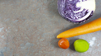 Vegetables cauliflower purple, carol, lime, tomato on rust stone wall background, veggies salad,...
