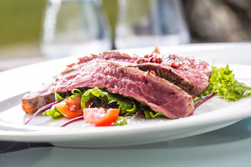 Close-up  juicy flank steak from vegetable salad.