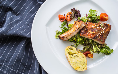 Grilled barbecue pork ribs in a white plate as menu in pub.