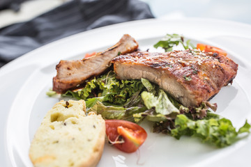 Grilled barbecue pork ribs in a white plate as menu in pub.
