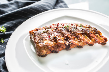 Grilled barbecue pork ribs in a white plate as menu in pub.
