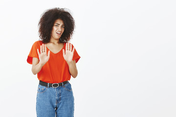 Gosh, take it away disgusting. Portrait of displeased unhappy african american woman with curly...
