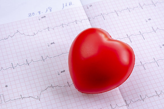 cardiograma con pequeño corazón rojo en primer plano de la mesa