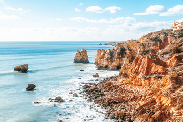 Panorama of Praia da Marinha on the south coast of Portugal in the Algarve on a sunny day. The cliffs, beach and Atlantic ocean are in view with tourists on the beach