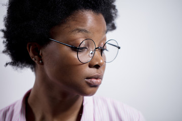 young pensive african woman feels lonely . close up side view portrait. isolated white background....