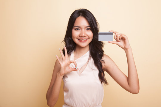 Young Asian woman show OK with a blank card.
