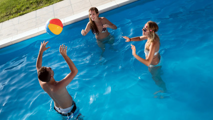 Friends playing ball games in pool