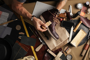 Shoe or belt maker working place at leather workshop with cobbler s and craft tools on background - obrazy, fototapety, plakaty