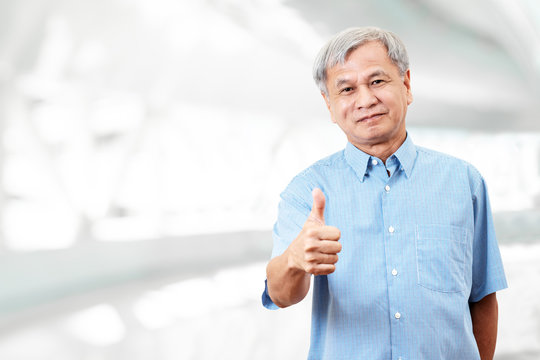 Portrait Of Happy Senior Asian Man Gesture Hand Showing Thumb Up Or Good Sign And Looking At Camera On Isolated Background Feeling Positive And Satisfaction. Older Mature Male Lifestyle Concept.