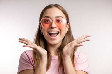 Close-up portrait of young beautiful stylish woman standing with open palms, isolated on white background. copy space. happiness, fun, luck, success concepts