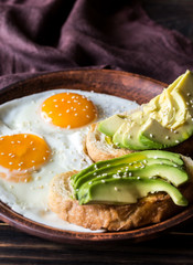 Fried eggs with toasts and avocado