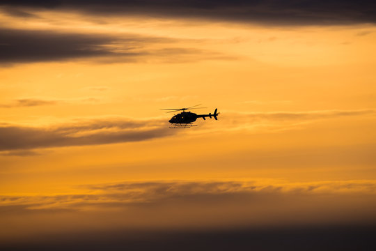 silhouette of helicopter at sunset
