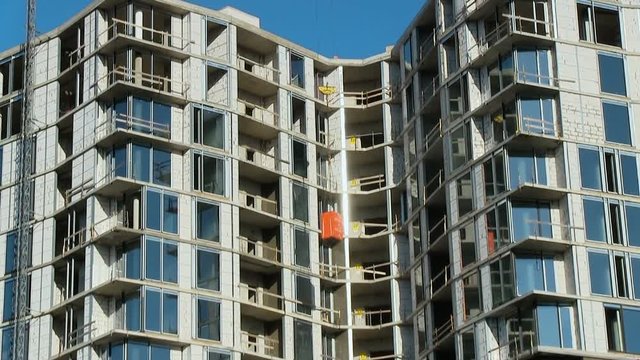 Construction, high-rise buildings, skyscrapers. Crane raises consumable building materials. Cement, glass wool long shot