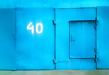 Obraz na płótnie Canvas Cyan closed garage door with numer 40 city background