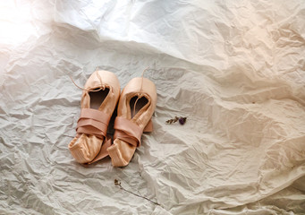 The ballet shoes on background,warm light tone,blurry light design background.