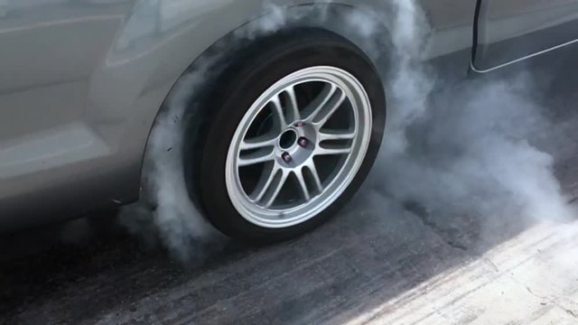 Drag car make tires warm up with smoke, Car racing burnout rubber off its tires in preparation for the race.