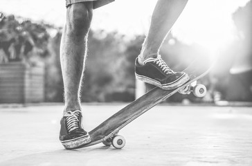 Skater performing with longboard at sunset in urban city square - Young trendy man having fun with...