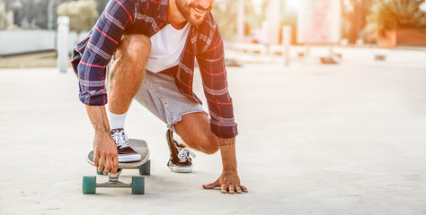 Tattooed skater performing with longboard at sunset in urban city square © DisobeyArt