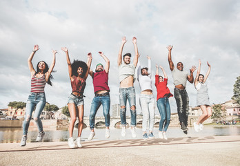 Happy millennials friends jumping outdoor