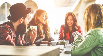 Happy trendy people having breakfast inside bar restaurant patio