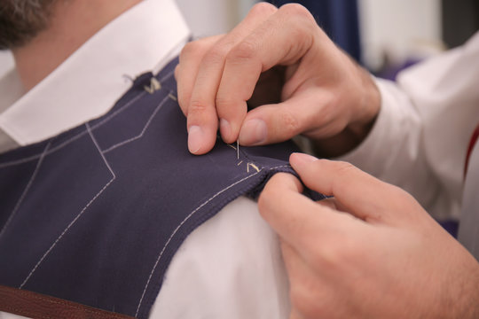 Tailor working on custom made suit in atelier, closeup