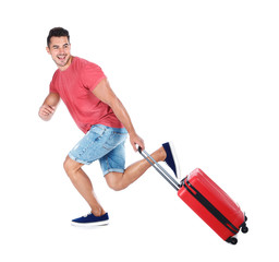 Young man running with suitcase on white background