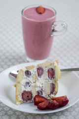 Fresh cream cake with fresh strawberries and rounded ladyfingers on the plate with fresh red fruits, strawberry milkshake