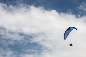 Silhouette of parachute on blue sky background