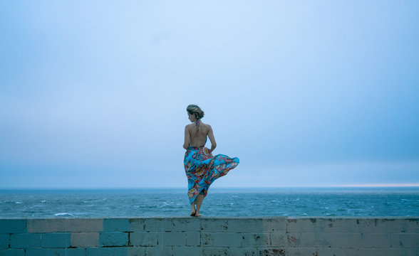 woman in dress in front of ocean