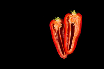 Paprika, two cut pieces of red bell peppers, isolated on black background. copy space.