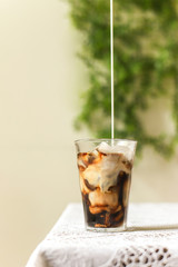 Iced coffee black coffee pouring the milk
