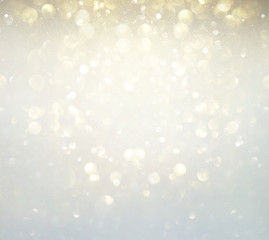 glitter vintage lights background. silver, gold and white. de-focused.