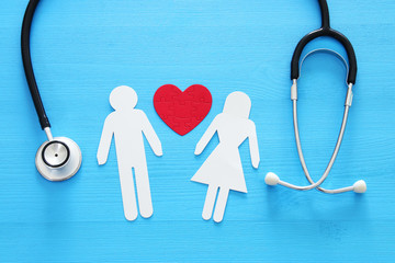 Health Insurance . concept image of Stethoscope and couple on wooden table. top view.