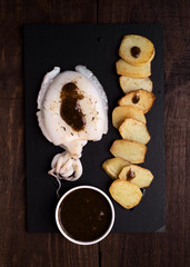 roasted sepia whole in black stone, on dark wood