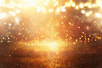 glitter vintage lights background. black and gold. de-focused.