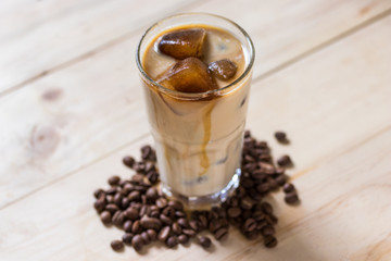 Espresso coffee frozen into ice cube mixed with milk on wooden background