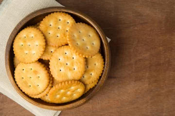 Foto op Plexiglas Round salted cracker cookies in wooden bowl putting on linen and wooden background. © Touchr