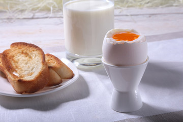 Morning Breakfast set with egg, orange jam on bread toast and milk in glass.