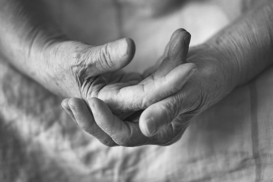 The hands of an elderly woman are connected together