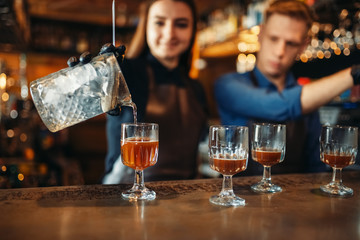 Male and female bartender at the bar counter