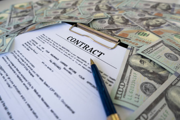 Sign contract for more money, US Dollar banknotes money on printed contract paper and pen to sign