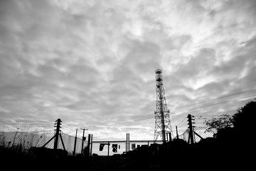 monochrome silhouetted telecommunications mast sited on farmland in rural Hampshire 