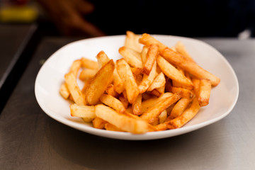French fries on a plate, isolated on white background.