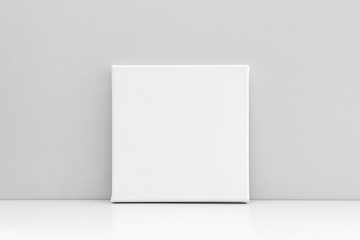 White square canvas on neutral gray background. Mock up poster, canvas template.