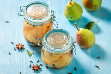 Homemade and healthy pickled pears on blue table