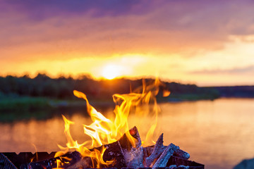 bonfire by the river at sunset