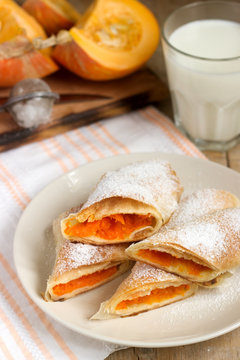 Traditional Romanian or Moldovan pumpkin strudel vertuta served with milk. Rustic style.