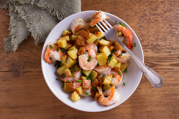 Shrimps with scallions and crispy potatoes. View from above, top studio shot