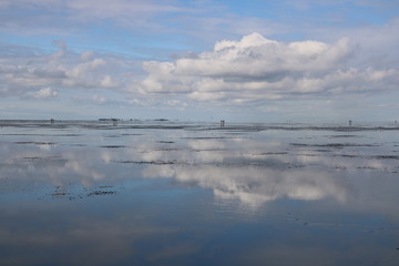 Nordsee bei Ebbe vor Cuxhaven mit Spiegelung der Wolken bei ablaufenden Wasser