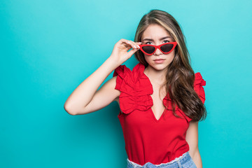 Young woman in sunglasses in summer dress isolated on blue background